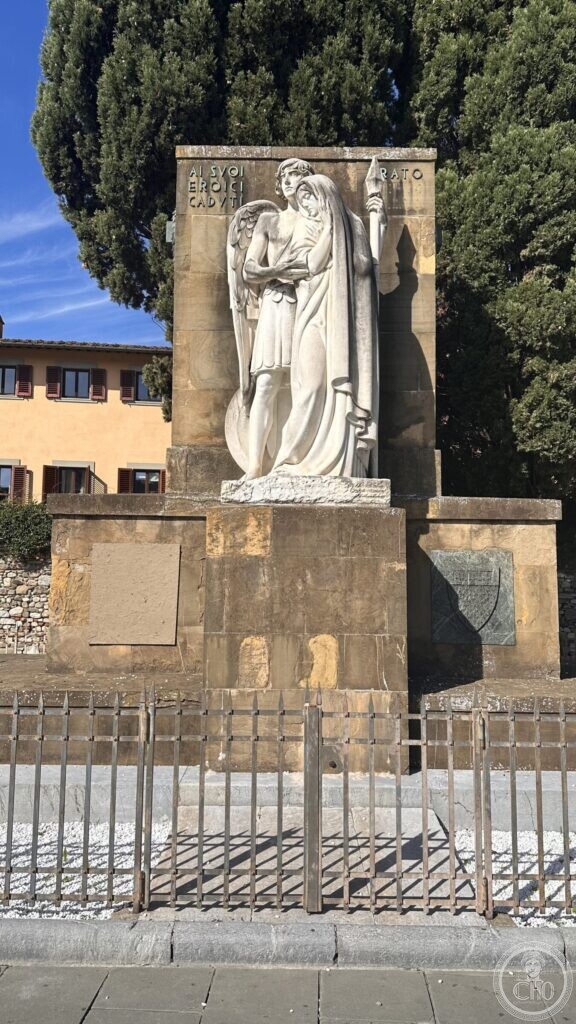 The war memorial of Prato seen from the street, a stone wall with a sculpted group