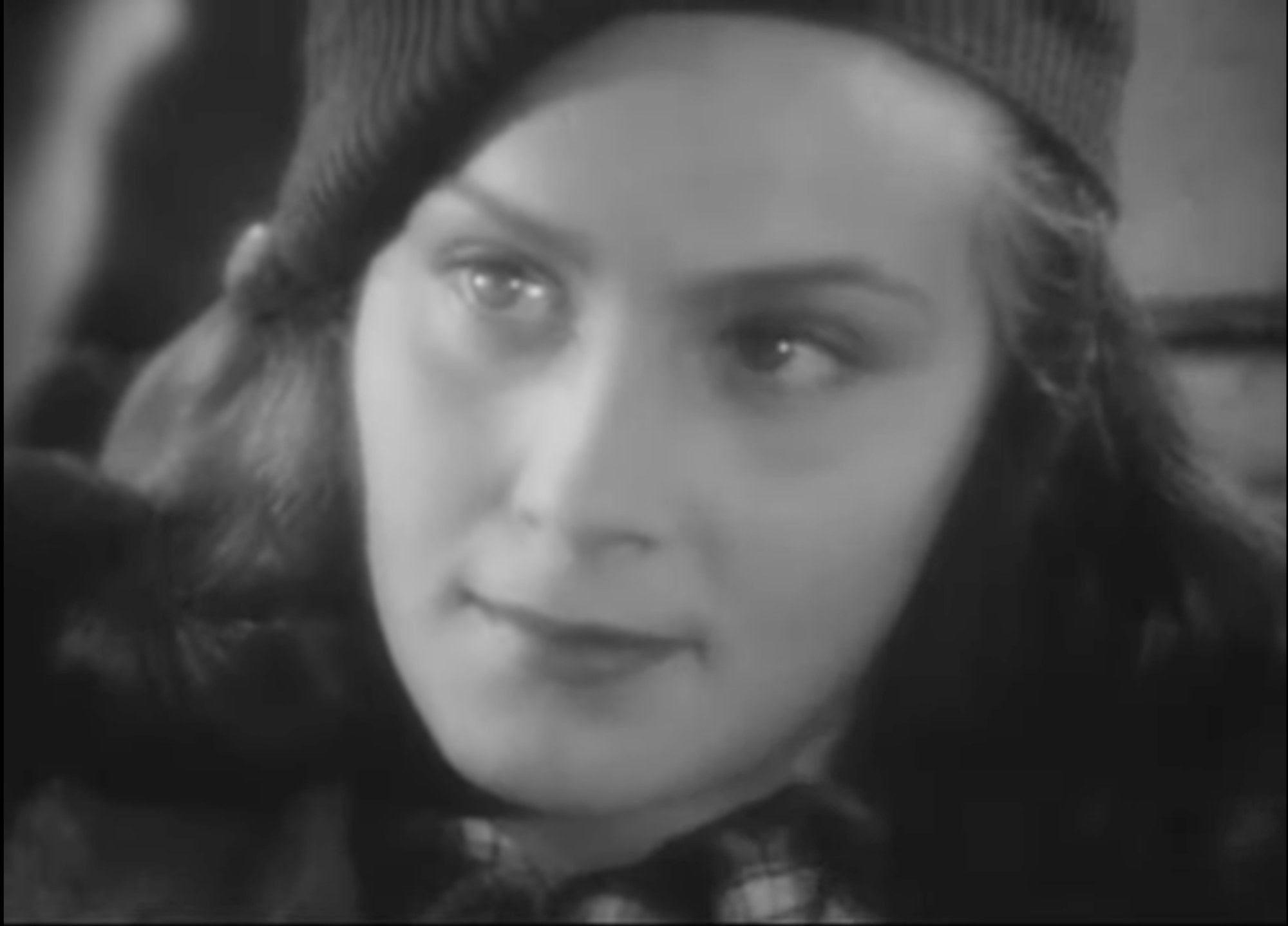 Alida Valli in close-up wearing a knitted cap, a frame from the 1942 film Noi vivi