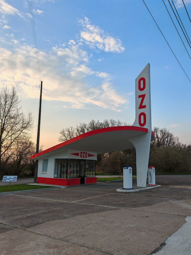 The OZO Bellevue service station at Sainte-Maure-de-Touraine, a low building under a tall red and white totem with the letters OZO