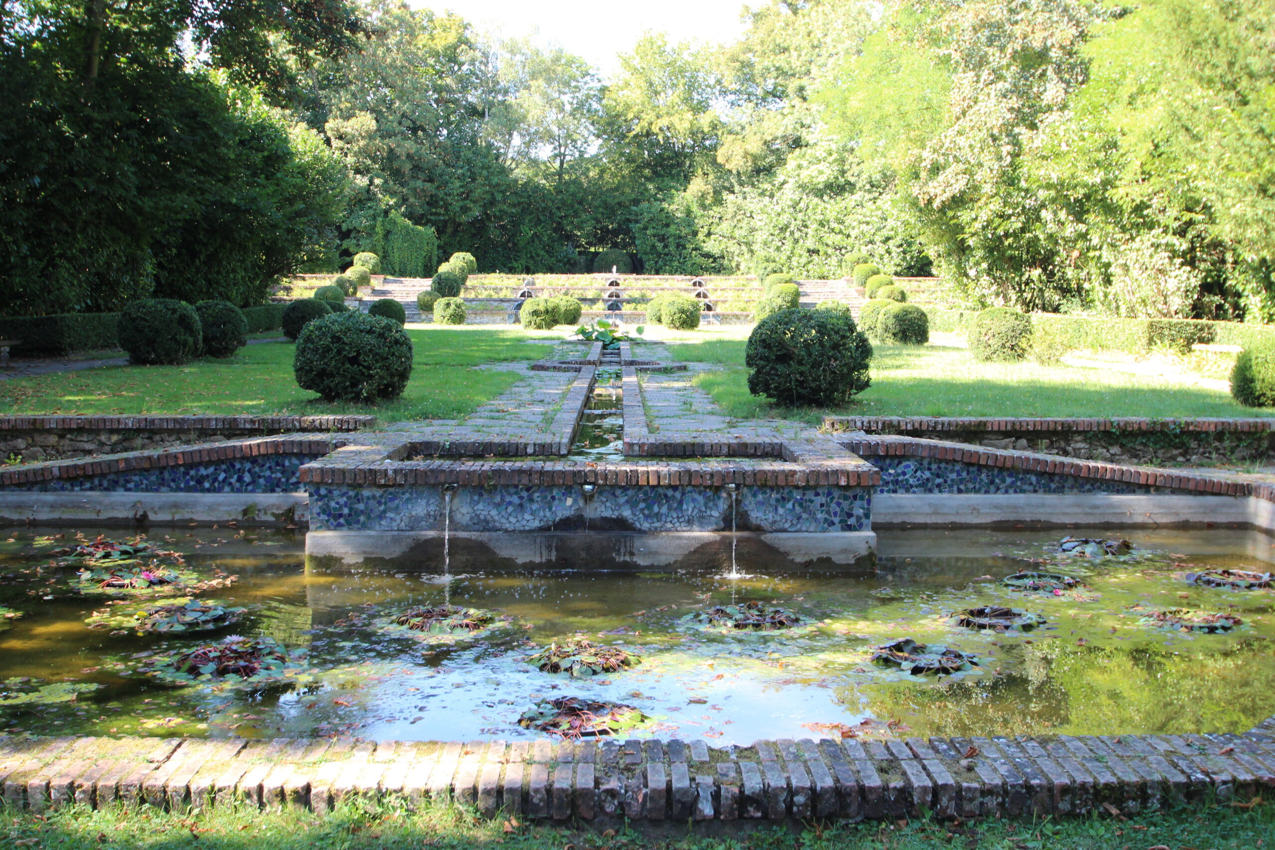 The central axis of the Parc Boussard at Lardy: a stepped water channel between brick-edged basins and clipped box