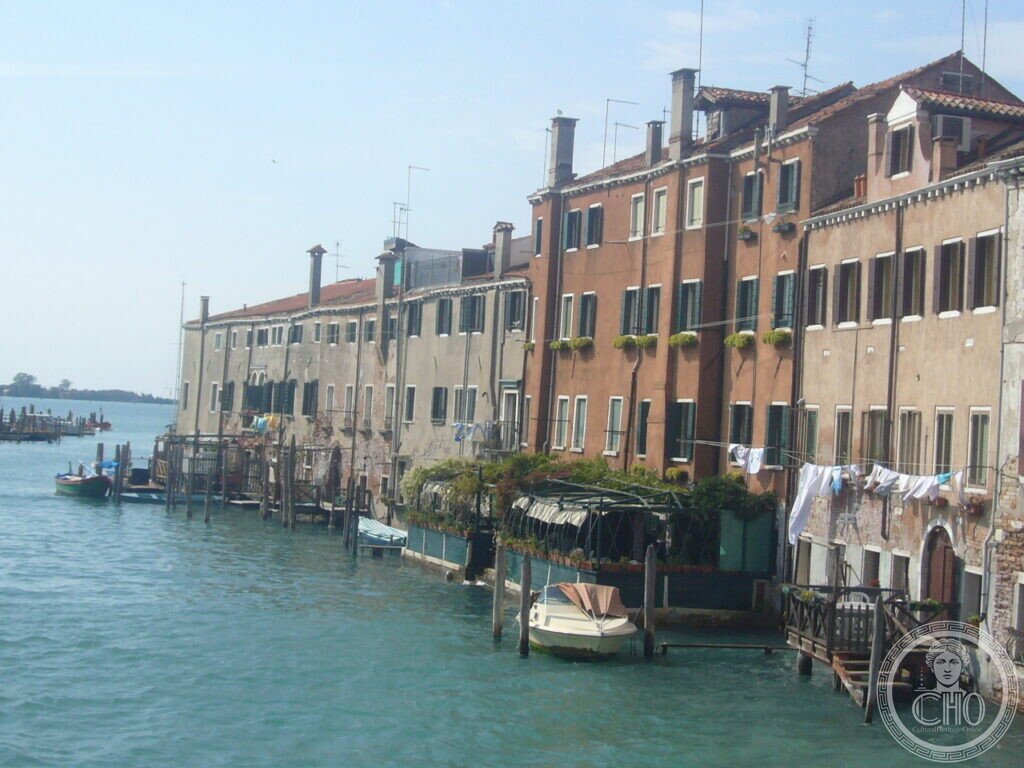 Houses of the Giudecca rising straight from the water, with washing lines and moored boats