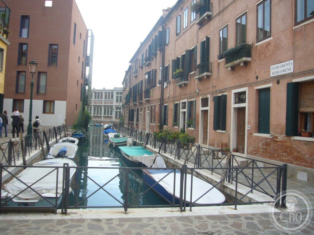 Quiet inner canal of the Giudecca at Fondamenta Berlomeni, lined with moored boats and doorstep gardens