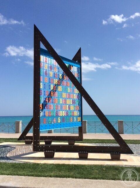 The weathered steel frame of the Pythagoras monument at Roccella Ionica against a blue sky