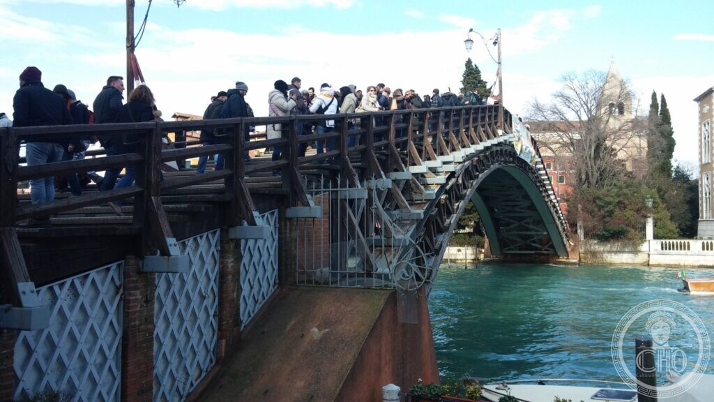 Close view of the metal lattice and rivetted arch beneath the wooden deck of the bridge