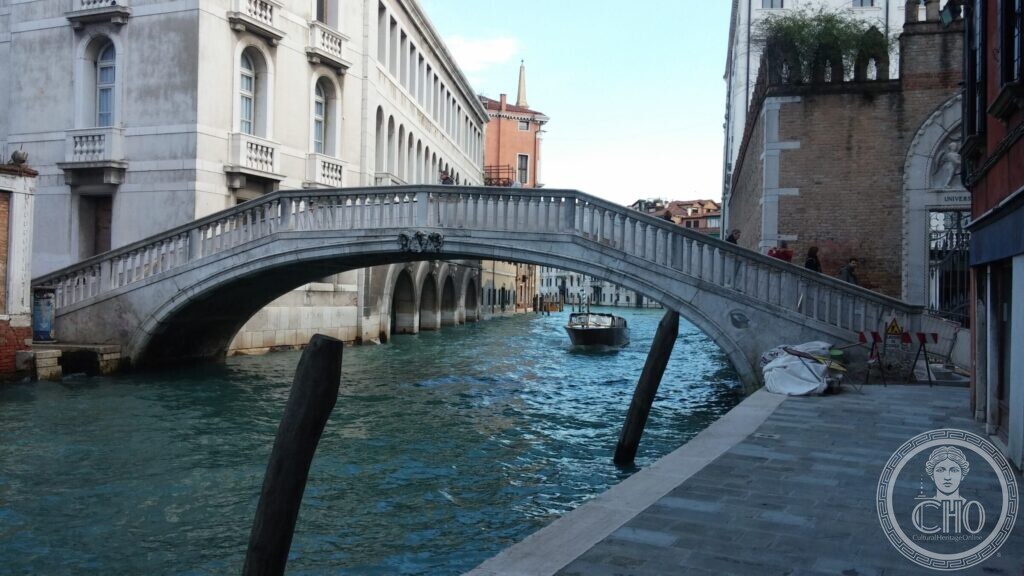 The Ponte de Ca' Foscari seen along the canal, with a bell tower in the distance