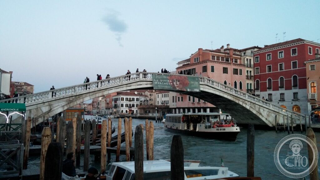 The Ponte degli Scalzi seen along the Grand Canal at dusk, with a vaporetto passing beneath