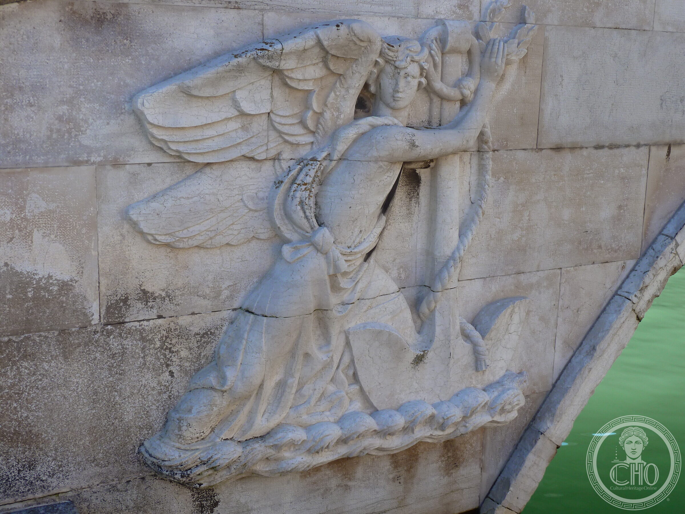 Second carved winged Victory with a streaming ribbon, cracked stone, on the Ponte de la Veneta Marina