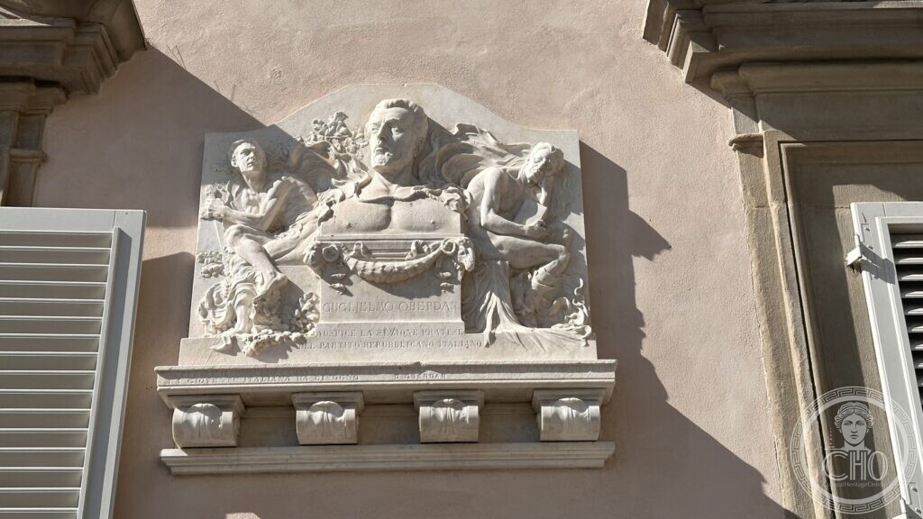 Marble high relief of Guglielmo Oberdan on the front of the Biblioteca Roncioniana, flanked by a youth with a torch and a woman with loose hair