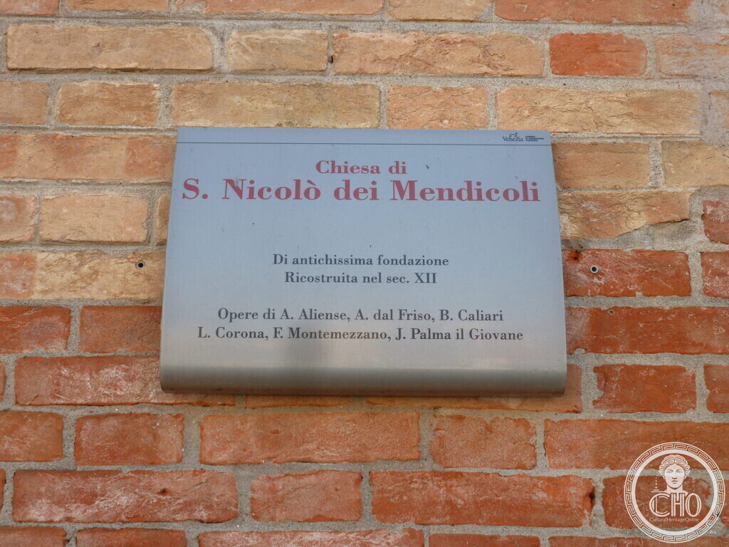 A grey metal plaque on a brick wall headed Chiesa di S. Nicolo dei Mendicoli, listing its dates and painters
