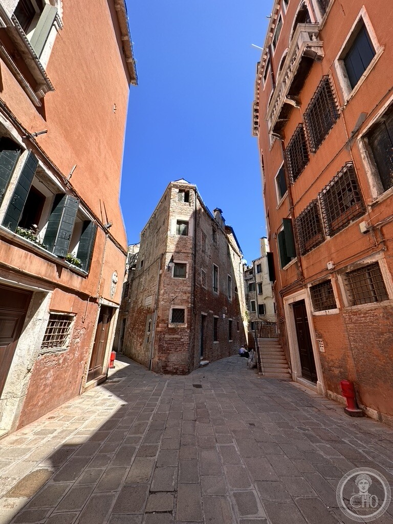 Triangular wedge-shaped historic Venetian building splitting two narrow alleys at Piscina San Samuele in San Marco Venice