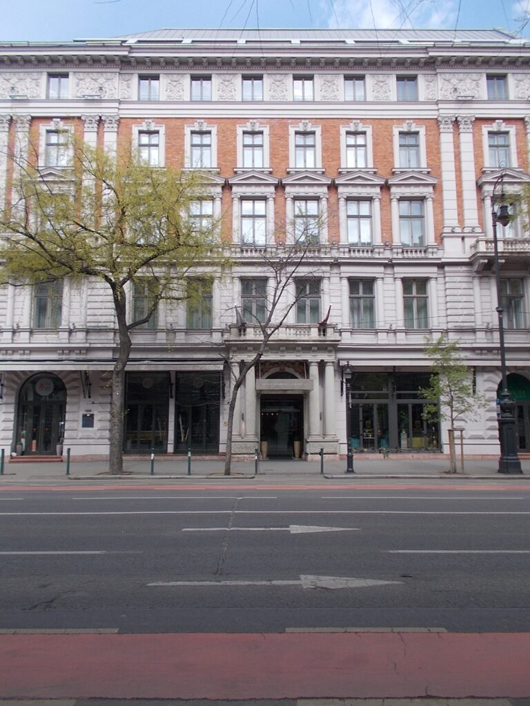 Five-storey Neo-Renaissance facade with red-brick panels between white stone pilasters, Andrássy út 8, Budapest