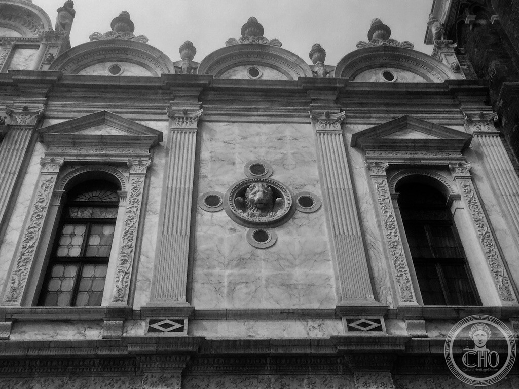Upper Renaissance facade of Scuola Grande di San Marco with marble pilasters, lunettes and Saint Mark lion tondo