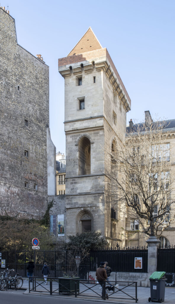 The Tour Jean sans Peur in Paris: a square tower of pale stone with a tall pointed-arch window, a machicolated parapet and a pyramidal red-tiled roof, seen from the rue Étienne Marcel