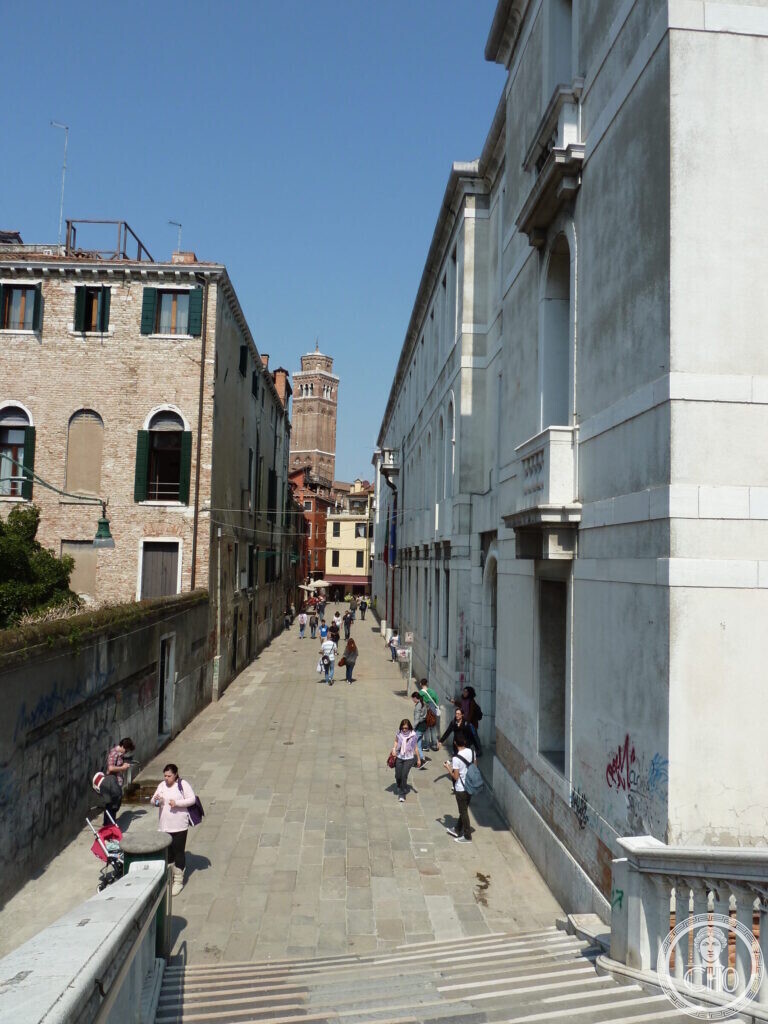 A long narrow street running beside the fire station, with a brick campanile in the distance