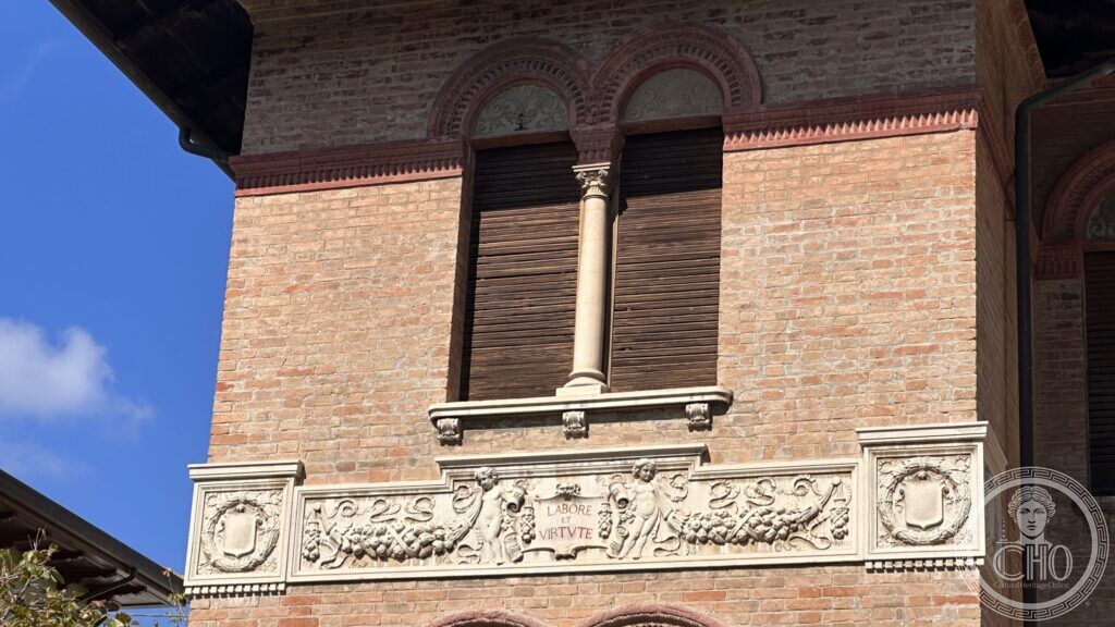 A carved stone frieze of putti and vine swags with a cartouche reading LABORE ET VIRTUTE