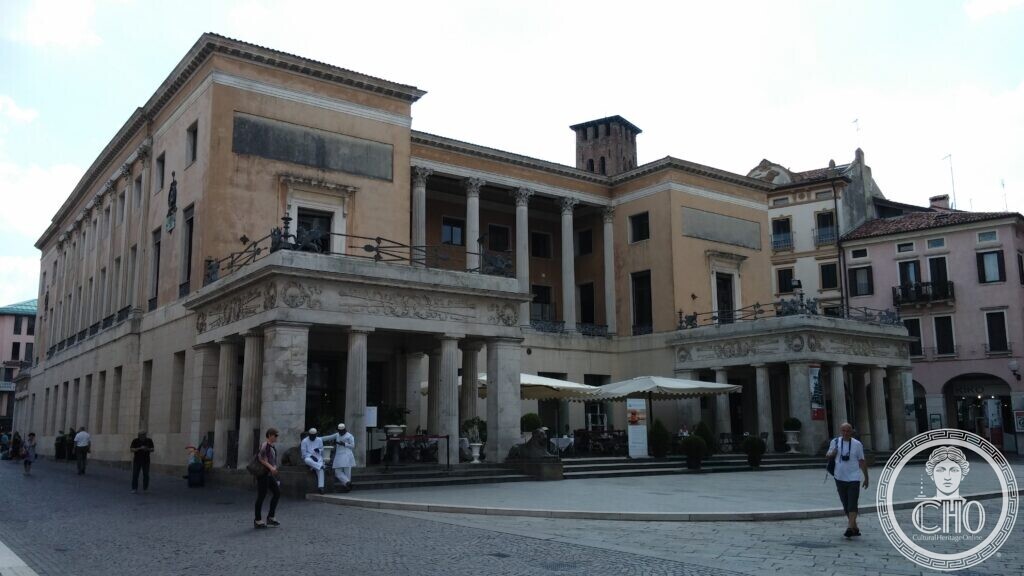 The neoclassical front of Caffè Pedrocchi in daylight, with its two porches of Doric columns, the loggia above and the stone lions at the steps