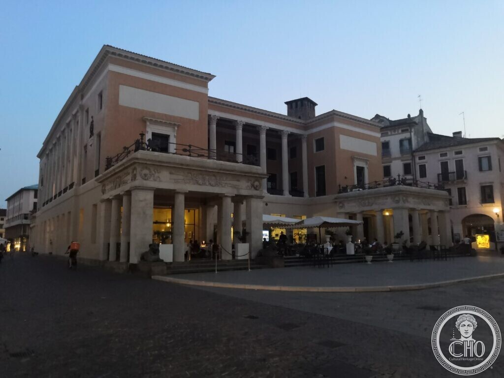 Caffè Pedrocchi in Padua at dusk, the two Doric porches lit from inside and tables set out on the raised terrace