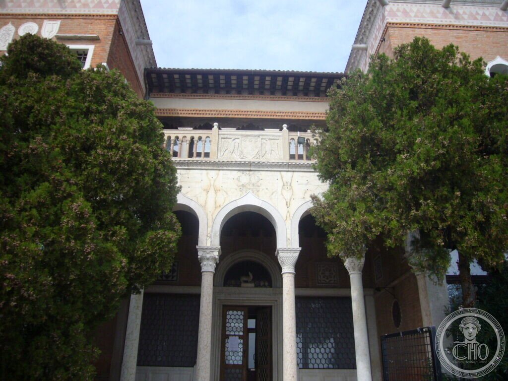 Main entrance of Villa Hériot with marble portico, carved arches and balustraded loggia above