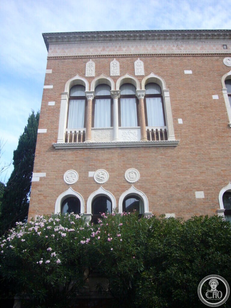 Four-light arched window with marble columns and Byzantine relief panels on the brick facade of Villa Hériot