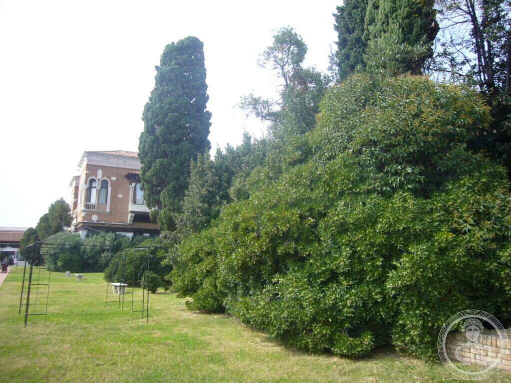 Lawn and hedges of the Villa Hériot garden, with the main villa visible in the background
