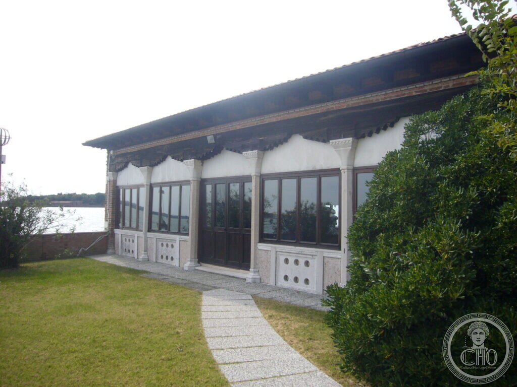 Single-storey pavilion with continuous glazing and pierced marble panels facing the lagoon in the garden of Villa Hériot