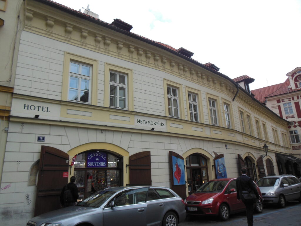 Long two-storey house on Malá Štupartská in Prague's Old Town with arched ground-floor openings, wooden shutters and a red tiled roof with dormers