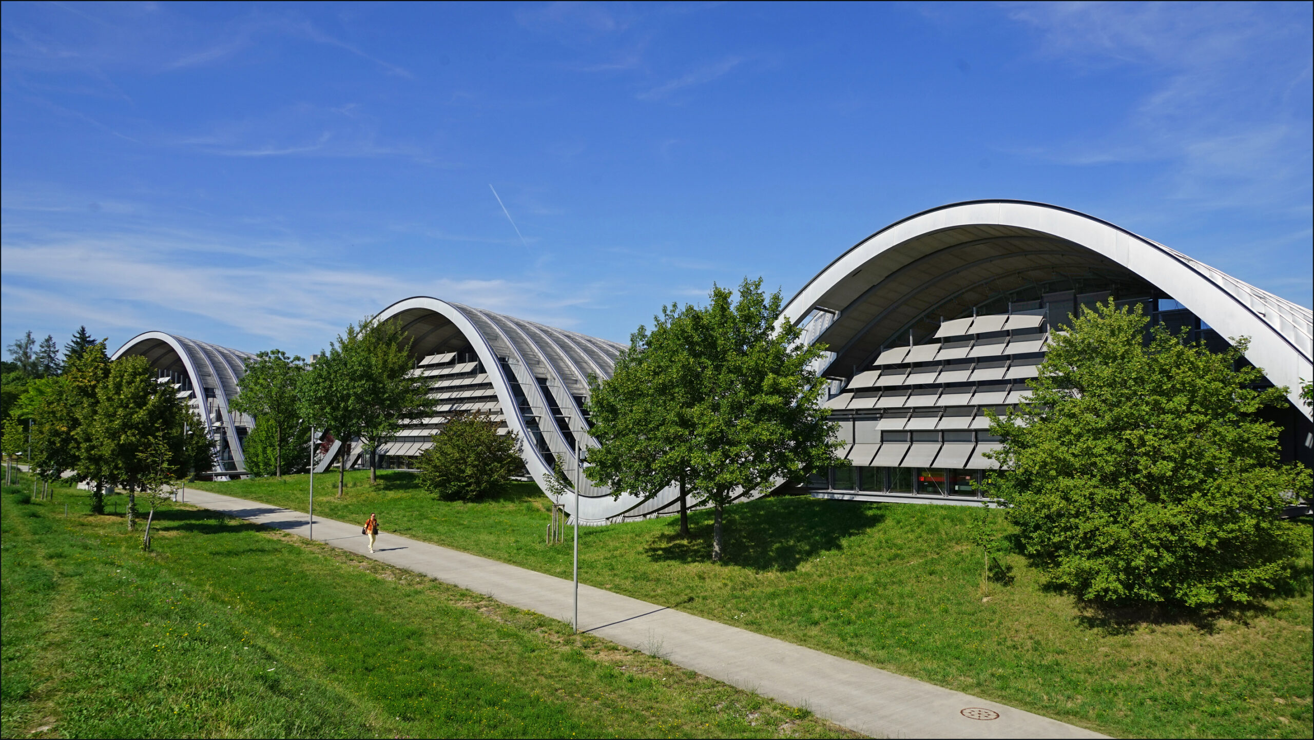 The undulating steel roof of the Zentrum Paul Klee rising out of a green field in Bern