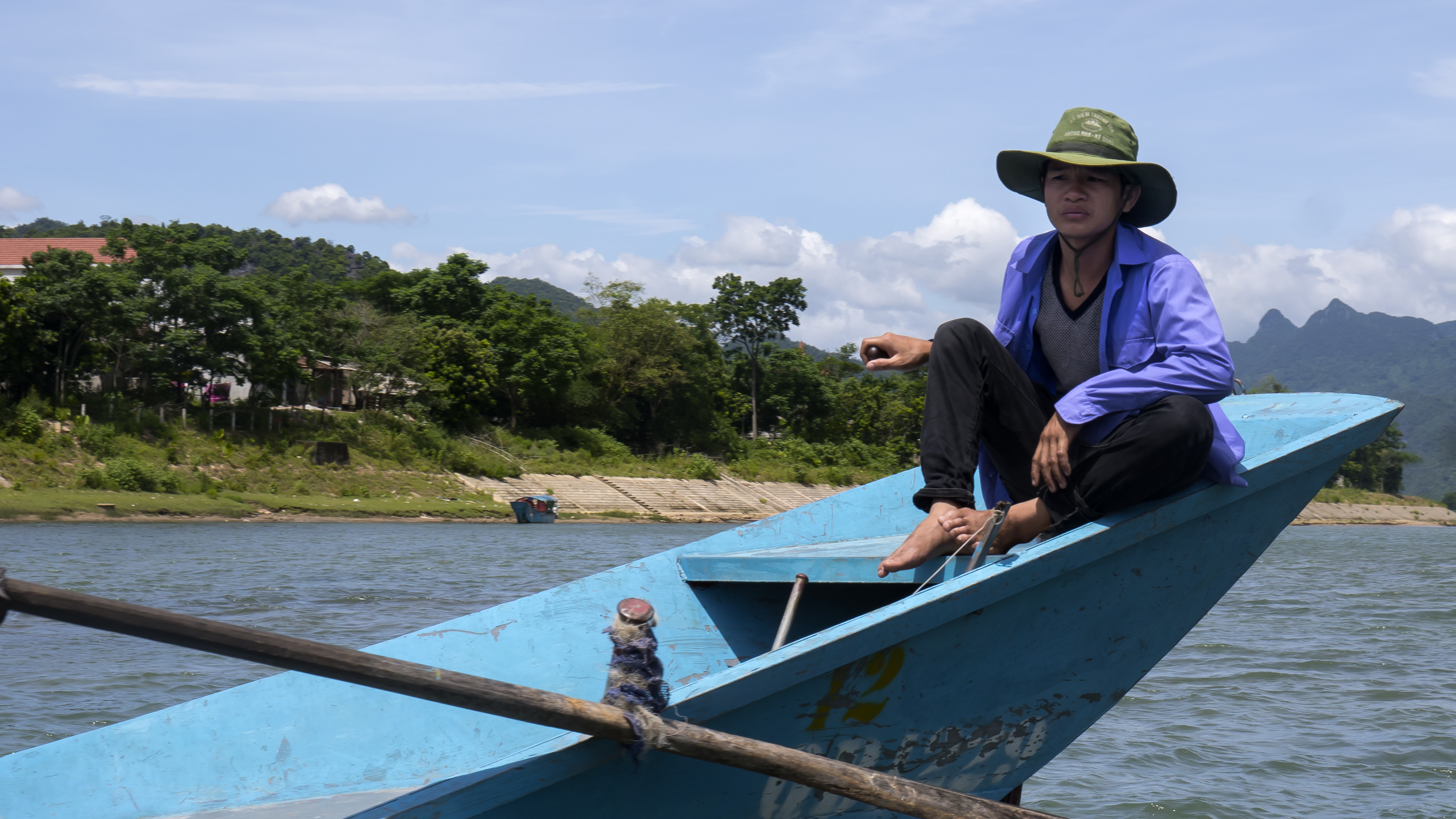 A boatman on the Son River below the karst hills of Phong Nha-Ke Bang