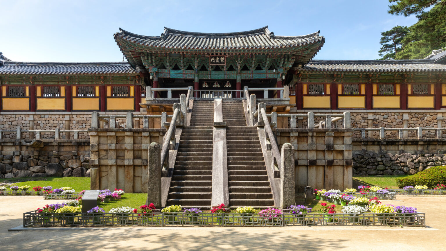 The two flights of stone stairs, Cheongungyo and Baegungyo, rising to the gate of Bulguksa above a long stone terrace and flower beds