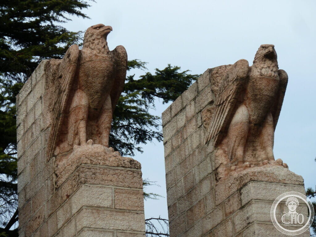 Close view of two eagles facing outward on their squared stone bases.
