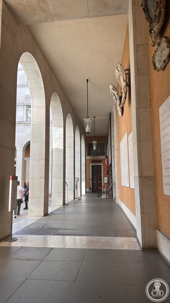 A long arcade corridor with plaques and ornaments on the wall