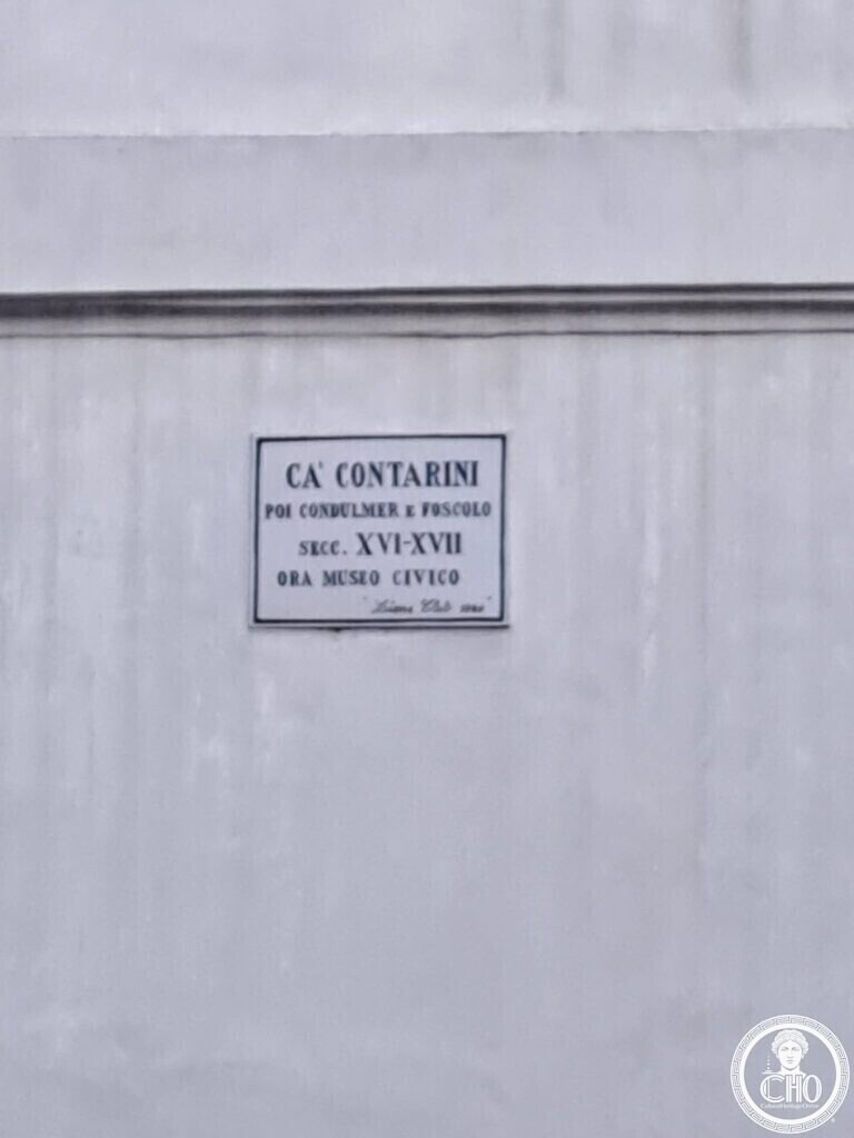 A small marble plaque on a white wall reading Ca' Contarini poi Condulmer e Foscolo, secc. XVI-XVII, ora Museo Civico