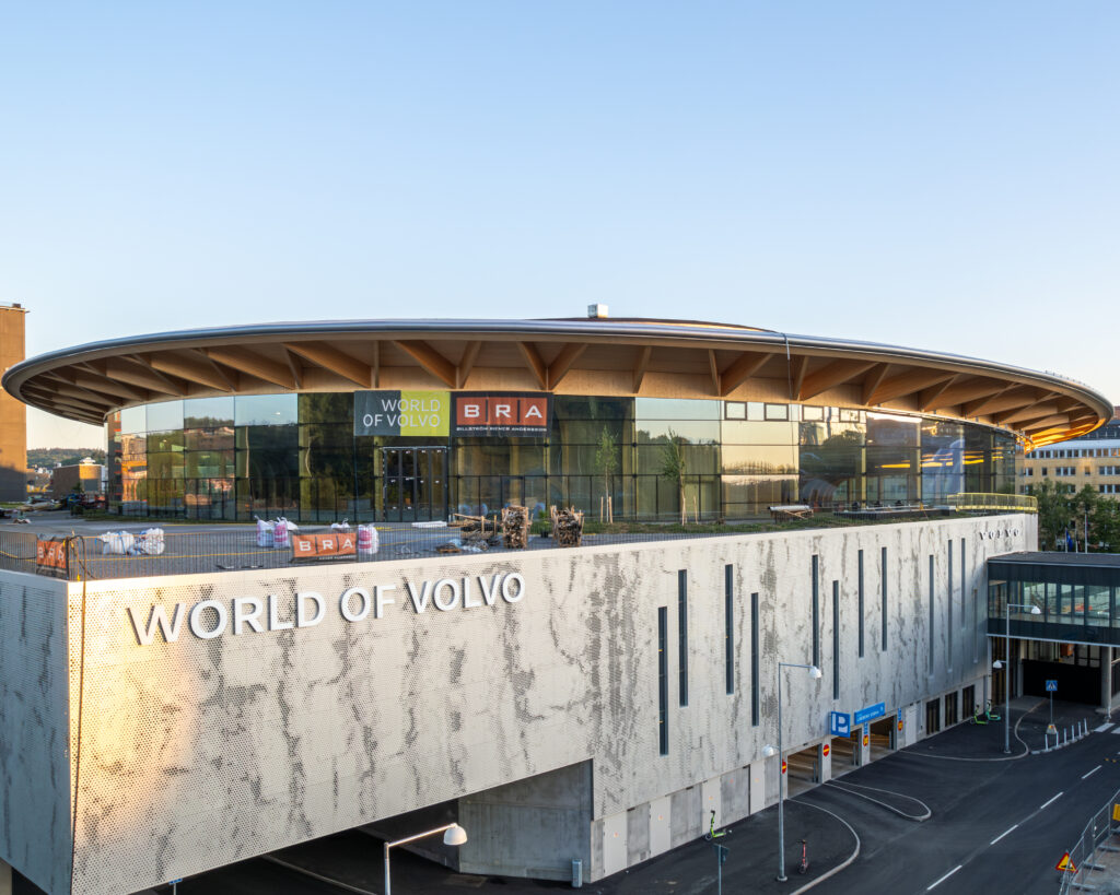 The curved mass-timber glass facade of World of Volvo in central Gothenburg